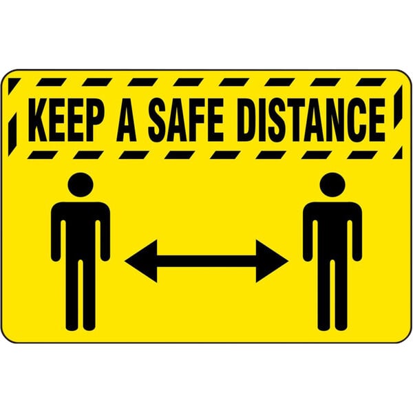 A yellow floor mat with black text and people standing next to each other with the words "Keep A Safe Distance"