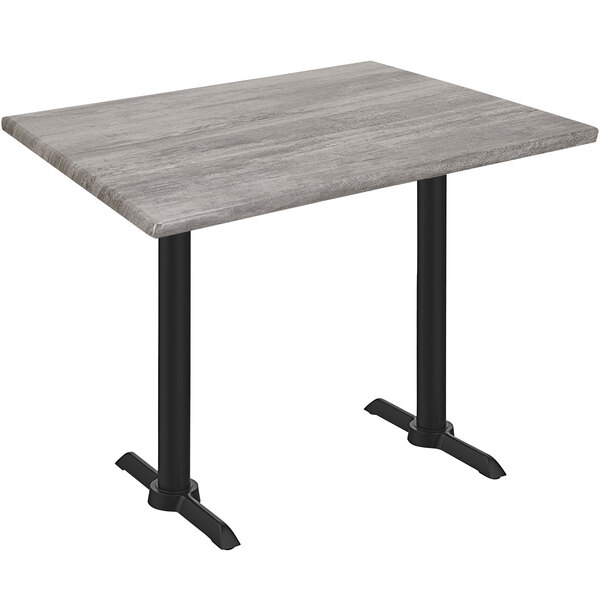A Holland Bar Stool Greystone Wood Laminate table with black end column legs.