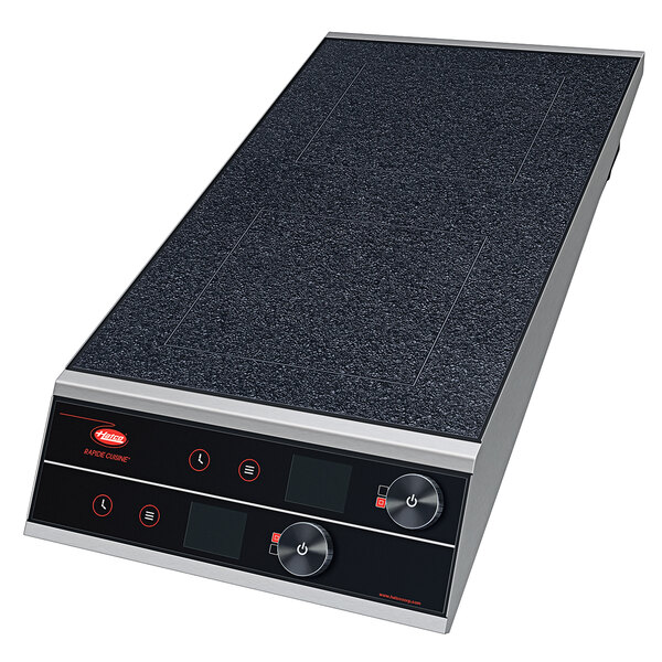 A black and silver Hatco dual induction range with knob control on a counter.