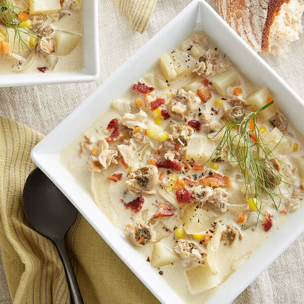 A bowl of Rappahannock Oyster Co. shucked oysters in soup with bread.