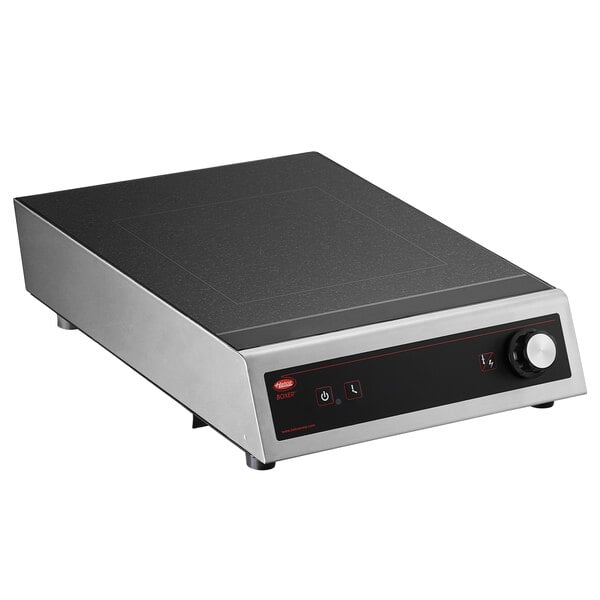 A black and silver rectangular object with a red knob.