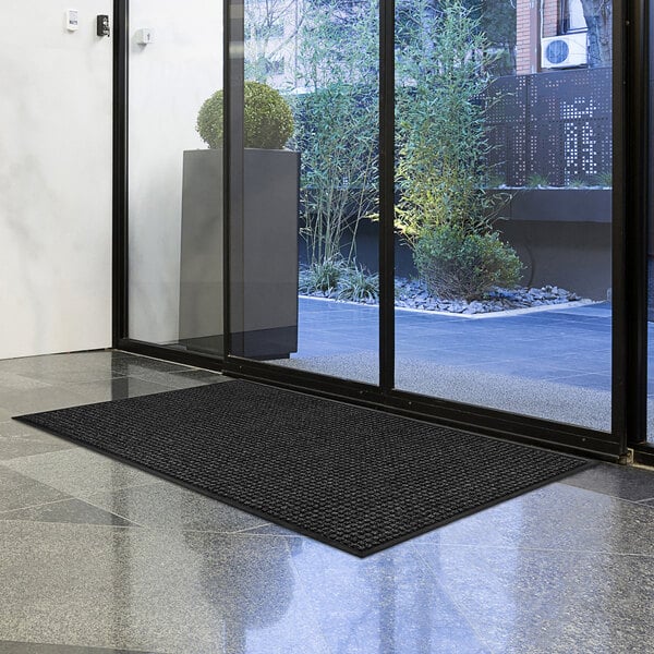 A black Lavex waffle entrance mat on a floor.