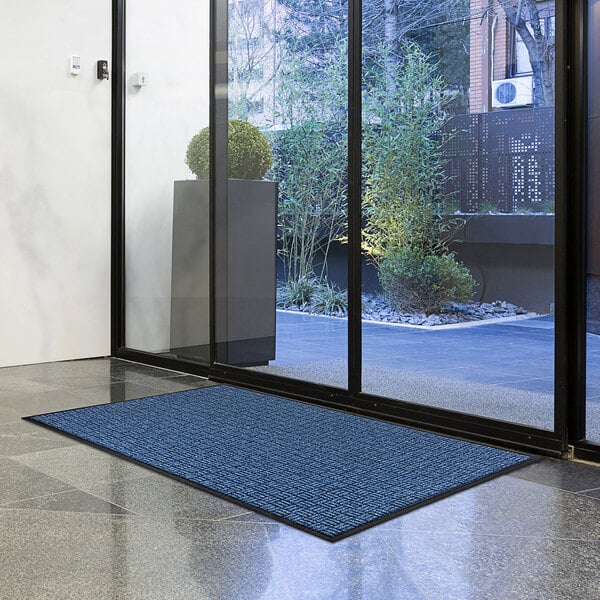 Blue indoor/outdoor mat at the entrance of a lobby