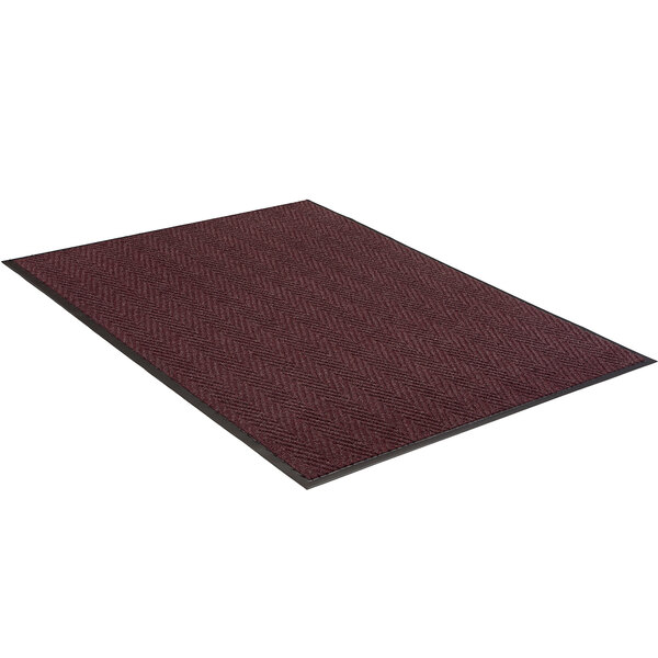 A close-up of a burgundy Lavex carpet with black trim in a chevron pattern.