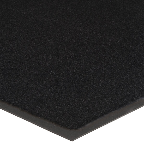 A rolled up black Lavex Olefin entrance mat.