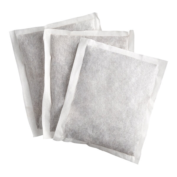 Three large rectangular filter bags filled with a dark substance, likely tea, are arranged overlapping on a white background.