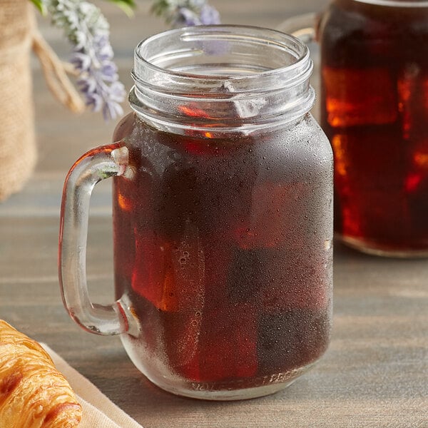 Two glass mason jars filled with Caribou Coffee Daybreak Morning Blend iced coffee on a white background.