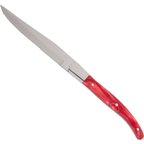 A Fortessa steak knife with a red handle and full tang blade.