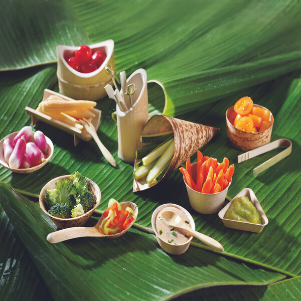 A variety of Solia bamboo leaf cones filled with vegetables on a table.