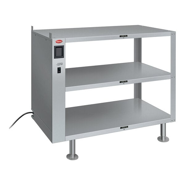 A grey metal Hatco heated take-out shelf with two shelves and a cord.
