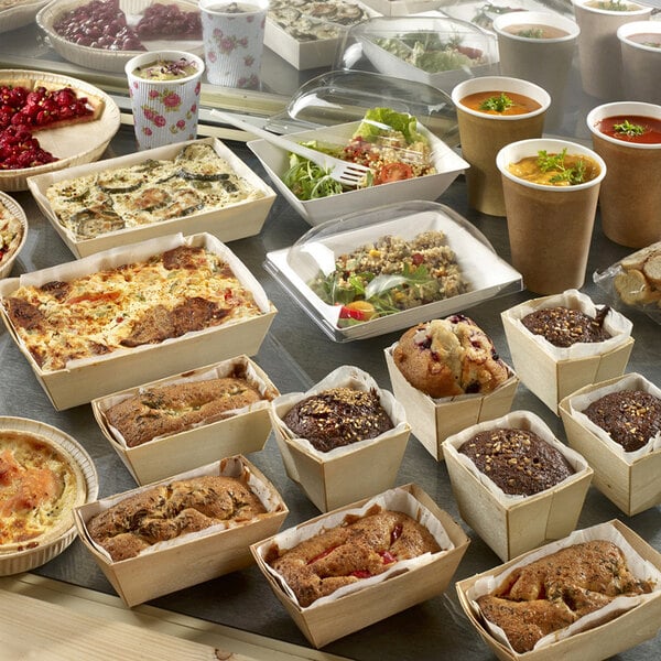A table filled with food in Solia wooden punnets lined with baking paper.
