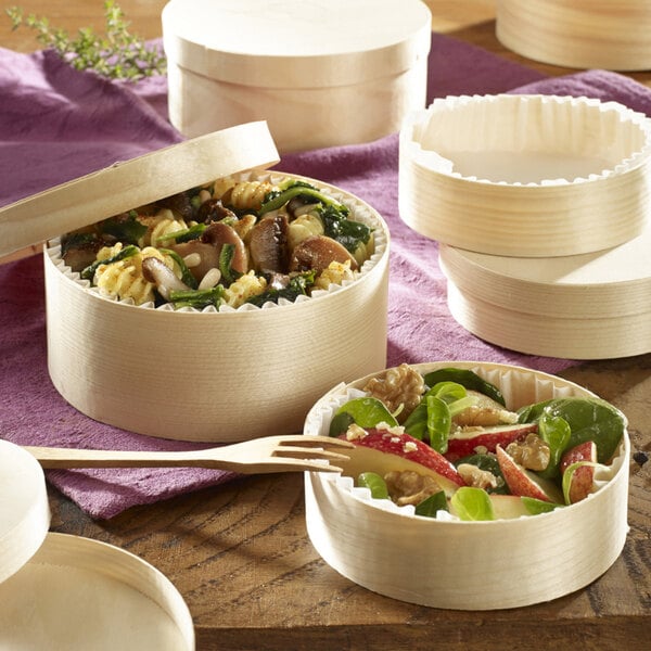 A Solia wooden baking box with a paper liner filled with food.