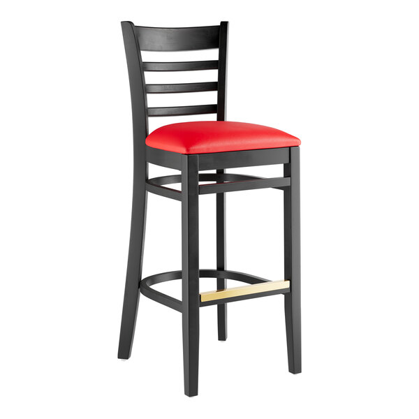 A Lancaster Table & Seating black wood bar stool with a red vinyl seat.