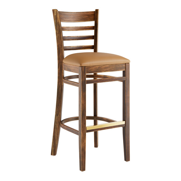 A Lancaster Table & Seating wooden bar stool with a light brown vinyl cushion seat.