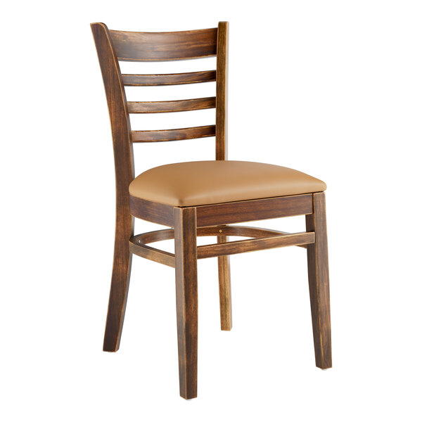 A Lancaster Table & Seating wooden ladder back chair with a light brown vinyl cushion