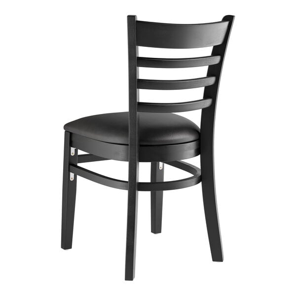 A Lancaster Table & Seating black wood ladder back chair with a black cushion