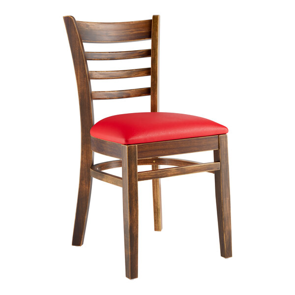 A Lancaster Table & Seating wooden ladder back chair with a red vinyl seat.