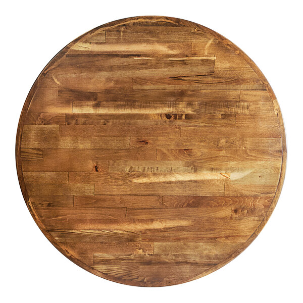 A Lancaster Table & Seating round wooden butcher block table top on a cast iron base plate.