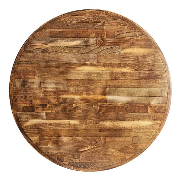 A Lancaster Table & Seating round wooden table top with a vintage finish on a cast iron base plate.