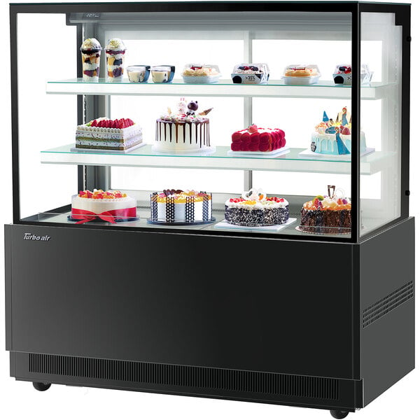 A Turbo-Air black refrigerated bakery display case with cakes on it.