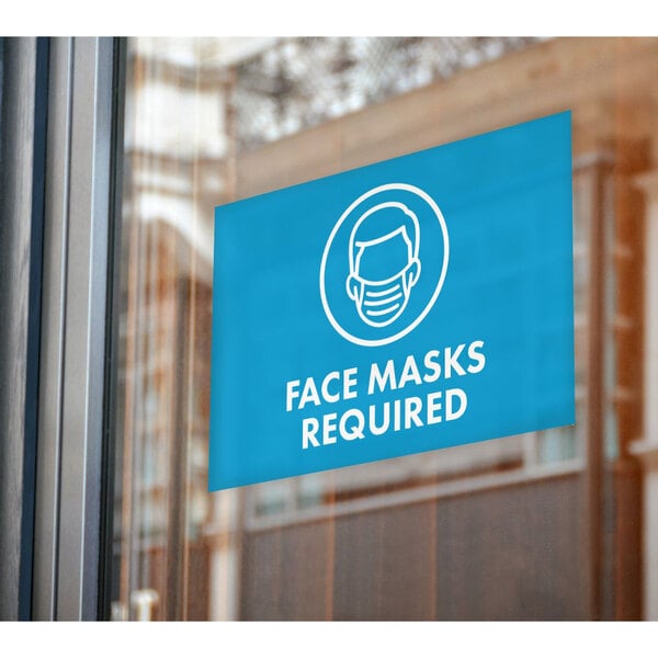 A blue rectangular window decal with white text that says "Mask Required" on a window.