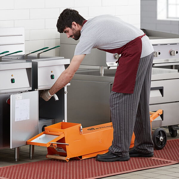 A man in a red apron using a Fryclone to move fryer oil.