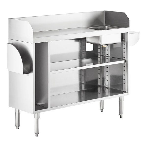 A stainless steel workstation with a raised back and sides, open shelving below, a small sink bowl on the right, and pan holders on each side.