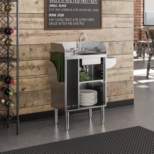 A stainless steel bussing and waitress station with a built-in sink bowl, pan holder, and storage shelves.