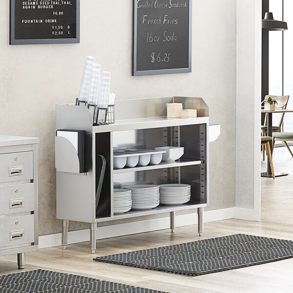 A Regency stainless steel waitress station with plates on a white counter.