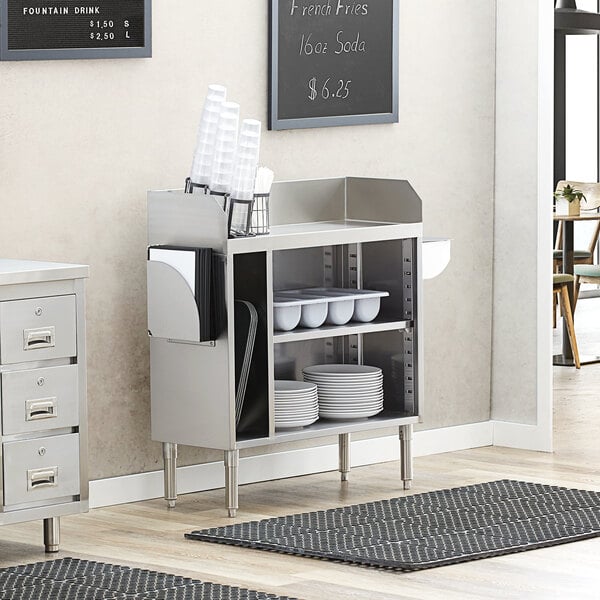 A Regency stainless steel waitress station on a white counter in a professional kitchen.