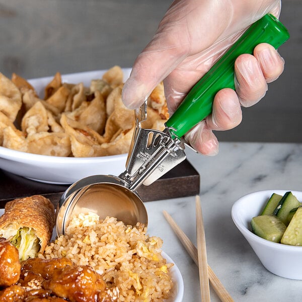 A person using a Carlisle Green Thumb Press Disher to serve food