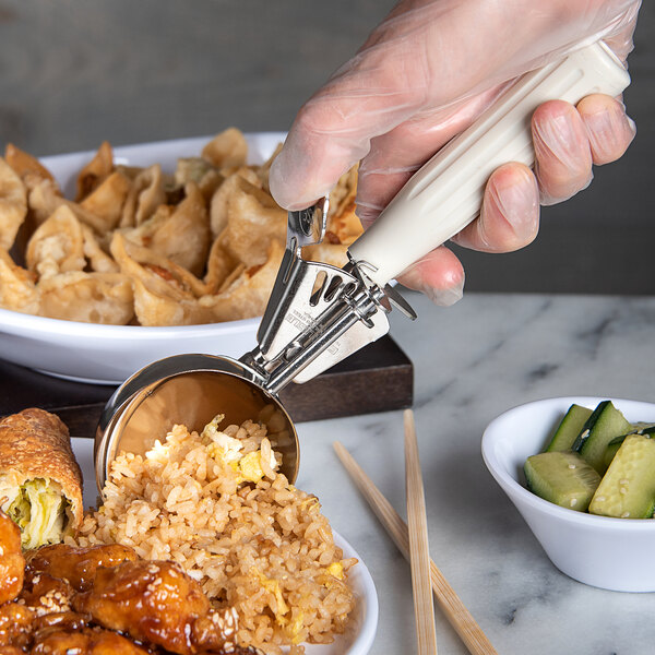 A hand using a Carlisle ivory metal scoop to serve rice