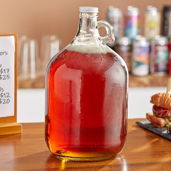 A large Acopa clear glass jug filled with liquid.