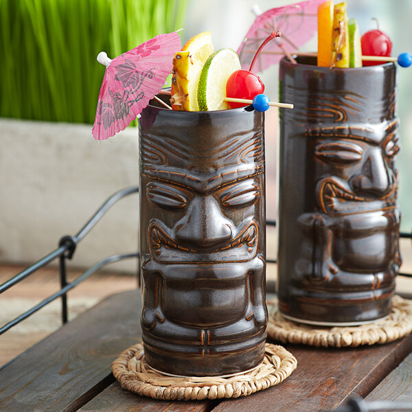 Two Tuxton ceramic tiki mugs filled with fruit and umbrellas.