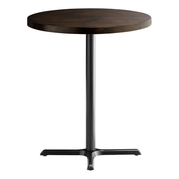 A round Lancaster Table & Seating wood butcher block table with a metal base.