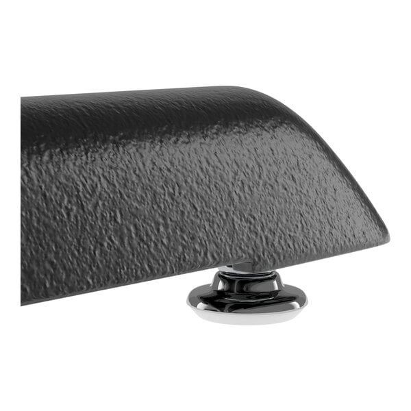 A close-up view of a textured black metal table base with a round chrome foot.