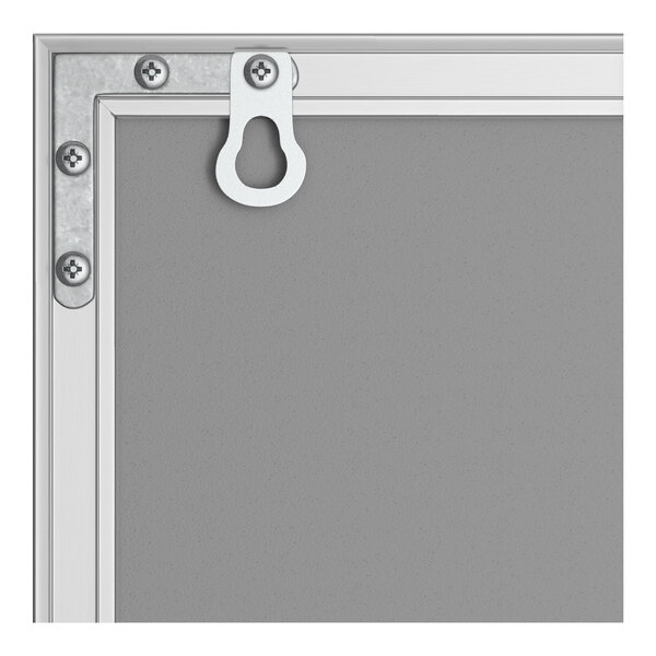 A corner view of a wall-mount melamine whiteboard with an aluminum frame and mounting hardware.