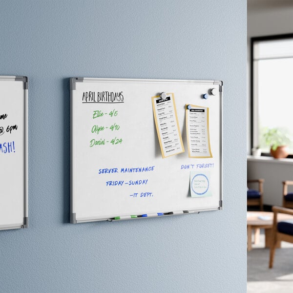A wall-mounted magnetic whiteboard with an aluminum frame measuring 24 by 18 inches.