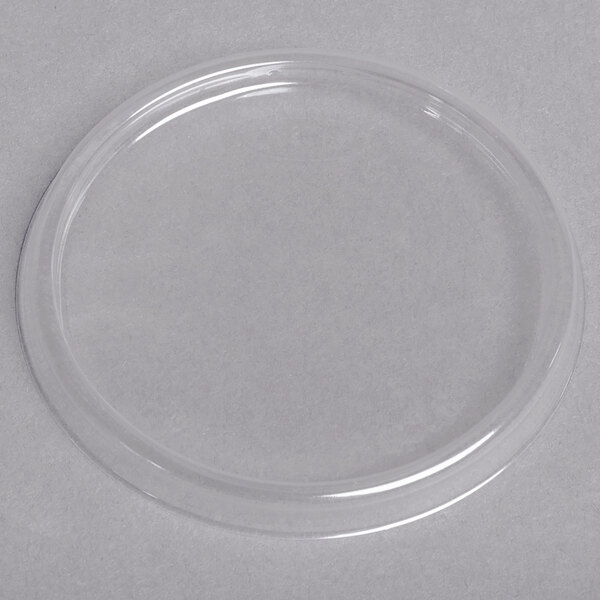 A clear plastic circle lid on a white surface.