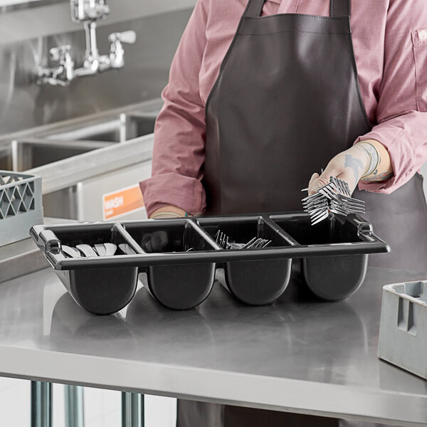 A black Vollrath cutlery box holding utensils.