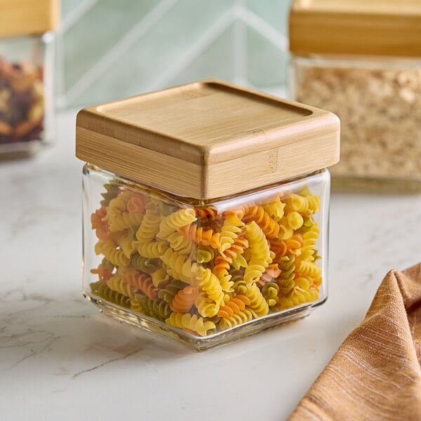 A 1-quart glass jar with a bamboo lid, filled with tri-color rotini pasta.