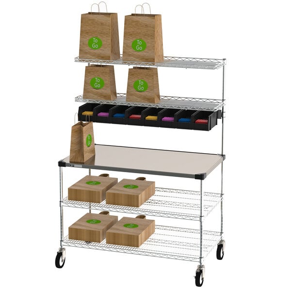 A Metro Drive-Thru Order Staging Cart with wire shelves holding bags and boxes.