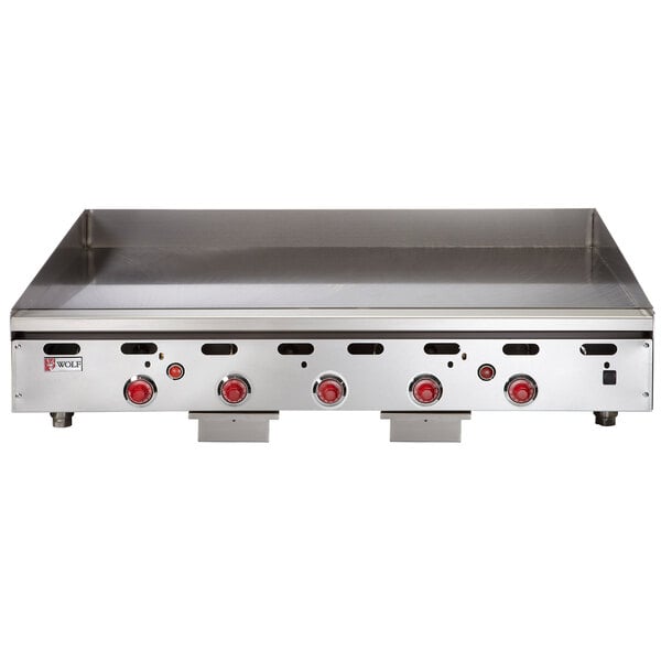 A Wolf stainless steel liquid propane griddle with red knobs.