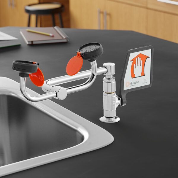 A right hand deck mounted eye and face wash station with a 90 degree swivel, installed beside a sink.