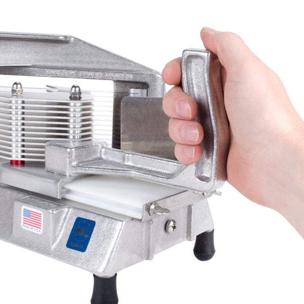 A hand holding a metal object with Nemco 55625-1 Tomato Slice Pusher attached.