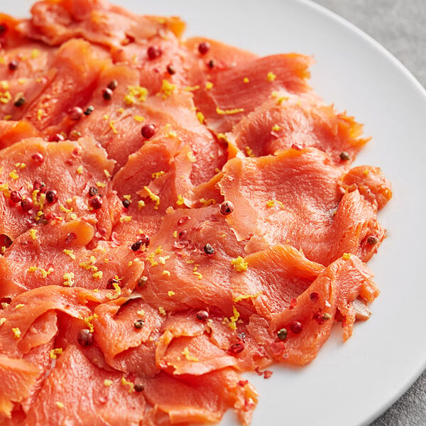 A plate of smoked salmon with Regal Pink Peppercorns on a table in a deli.