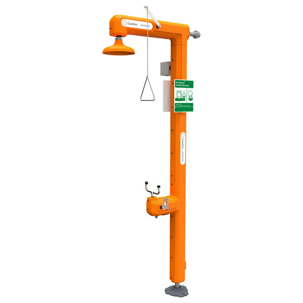 A Guardian Equipment heated safety station with an orange eyewash and green sign.