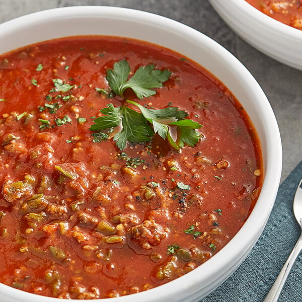 A bowl of soup with diced green bell pepper.