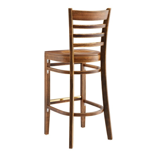 A Lancaster Table & Seating wooden ladder back bar stool with a vintage wood seat and back.