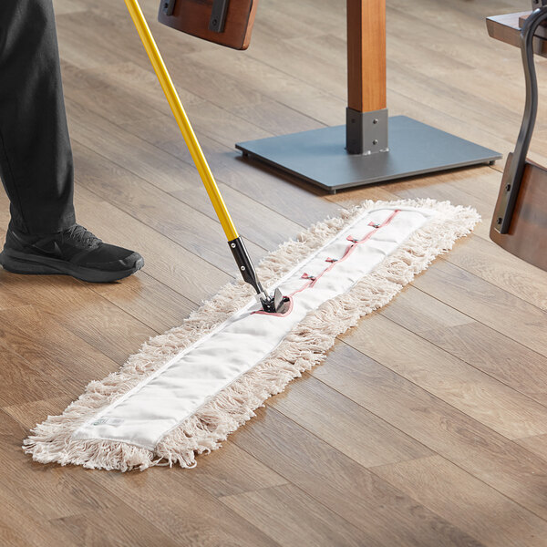 A person using a Choice natural cotton dry mop to clean a floor.